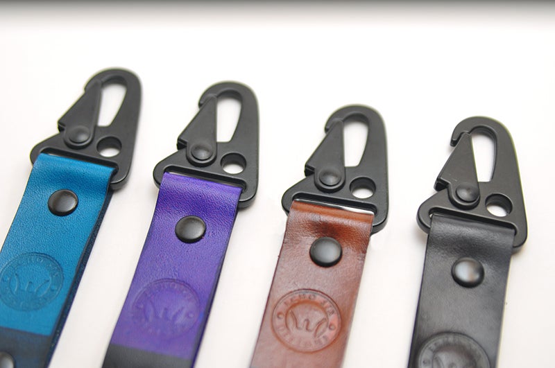 Handmade full grain leather Brazilian Jiu Jitsu ranked keychains, featuring colorful belt designs representing various ranks
