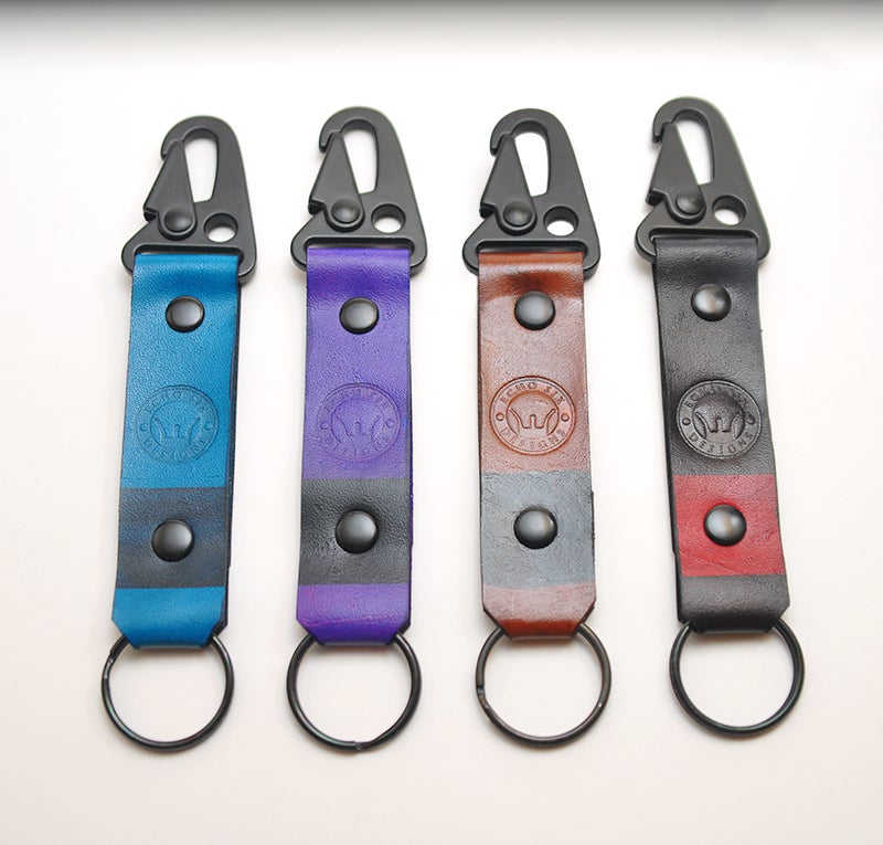 Handmade full grain leather Brazilian Jiu Jitsu ranked keychains, featuring colorful belt designs representing various ranks